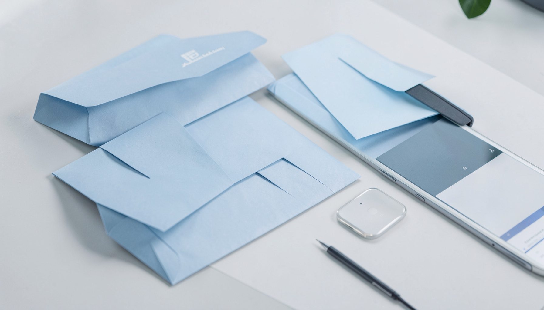 Abstract email marketing workspace with soft blue and gray tones, envelopes and digital devices arranged on a clean desk surface